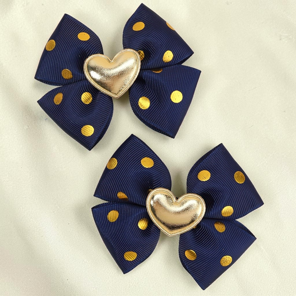 Paire de barrettes Le Cocon d'Or bleu marine à pois dorés avec un cœur métallique central élégant