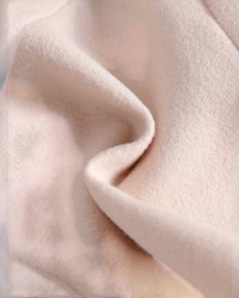 Gros plan sur le tissu en polyester beige doux et texturé de la tenue Le Cocon d'Or pour petite fille