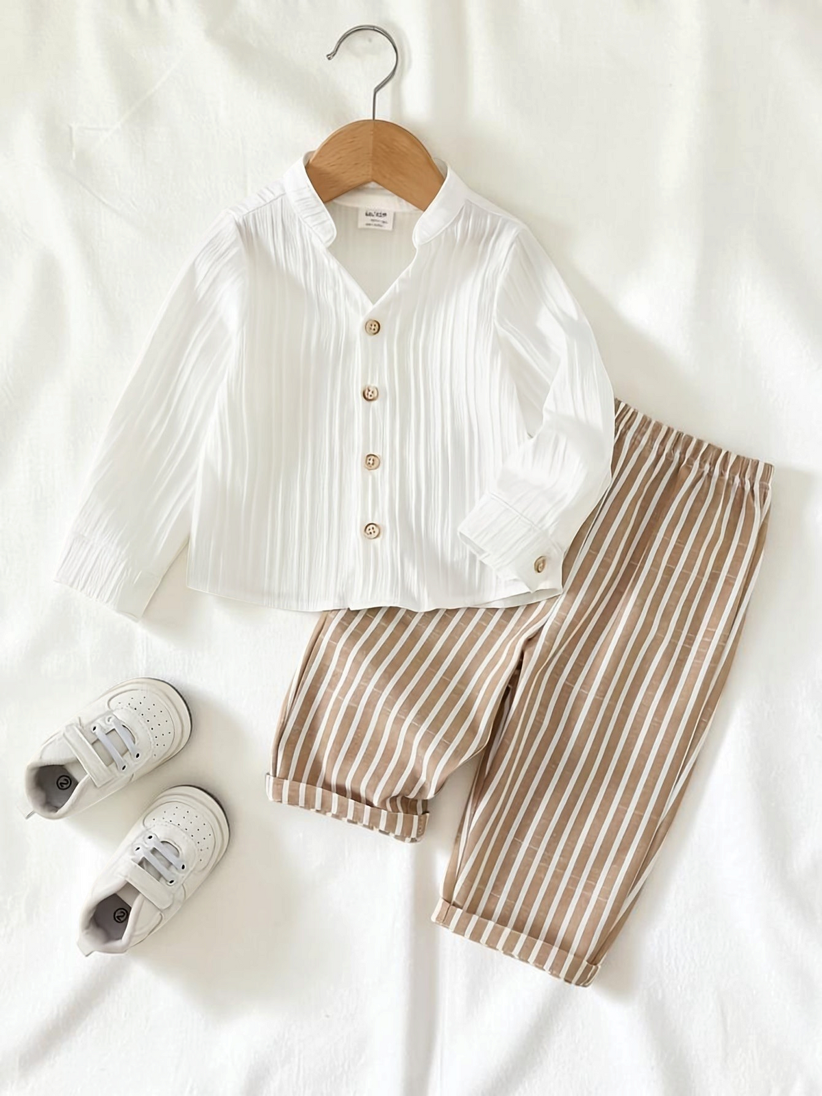 Ensemble Le Cocon d'Or pour garçon avec chemise blanche à boutons et pantalon rayé beige, style décontracté en été.