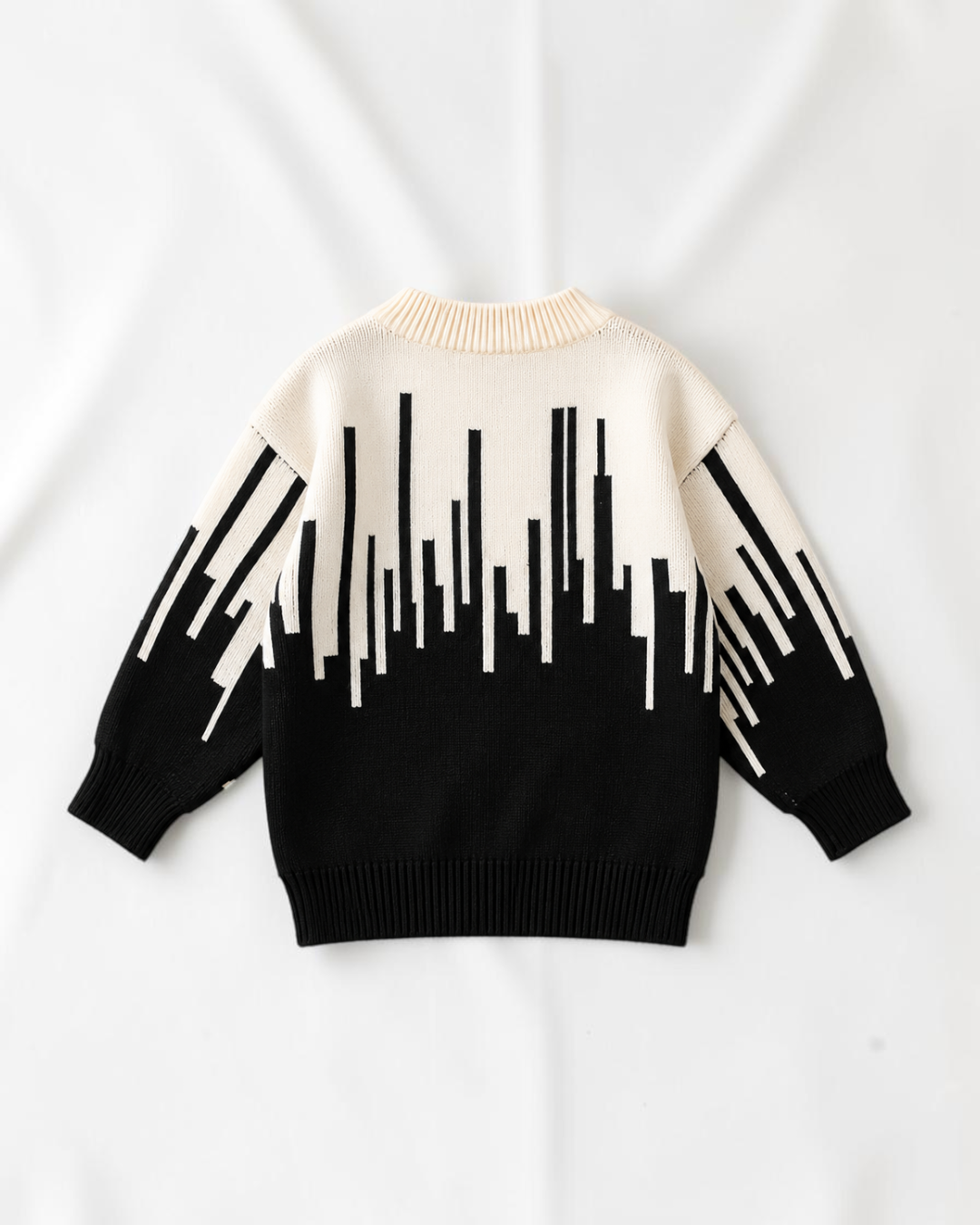 Pull en tricot Le Cocon d'Or pour bébé garçon, noir et blanc avec motif abstrait, col rond et manches longues.