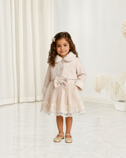 Petite fille portant un ensemble Le Cocon d'Or beige avec robe en maille, nœud papillon et manteau en fausse fourrure