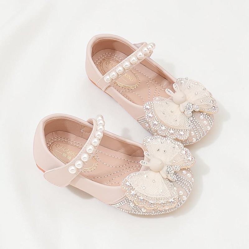 Chaussures Le Cocon d'Or style princesse beige avec nœud orné de perles et strass, bride à scratch et bout carré.