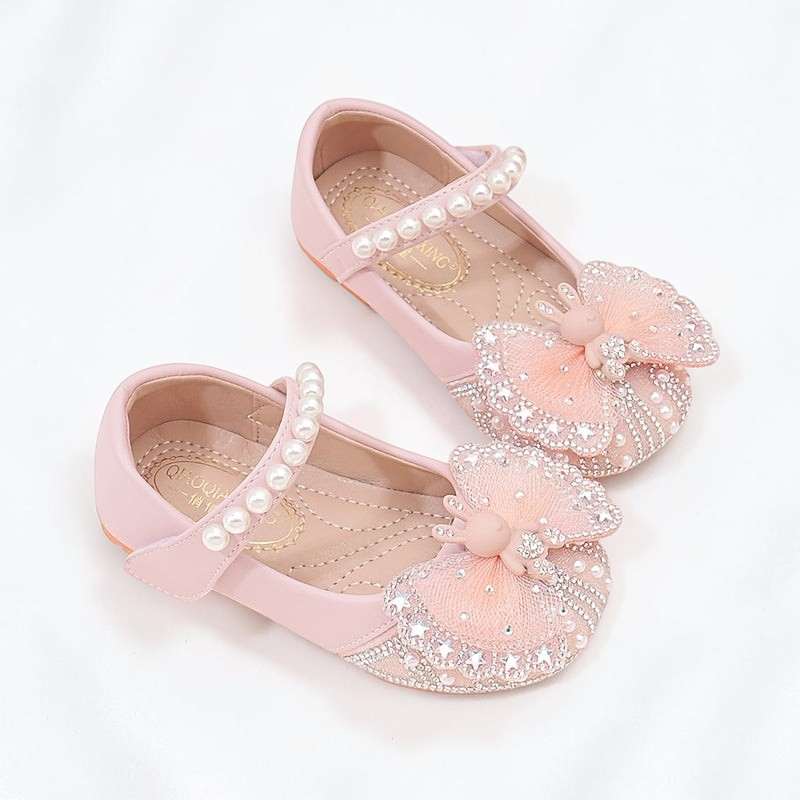 Chaussures de princesse Le Cocon d'Or roses avec nœud en tulle, perles et strass, fermeture à bride auto-agrippante.