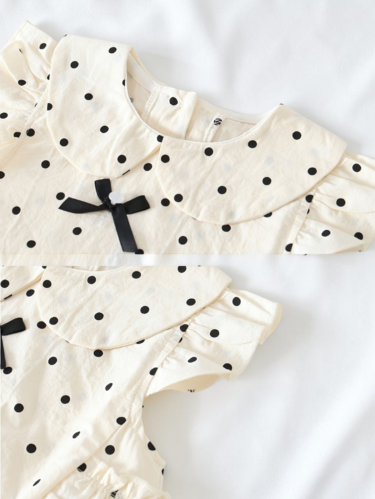 Barboteuse Le Cocon d'Or en coton blanc à pois noirs, col Peter Pan, nœud décoratif et manches papillon pour bébé