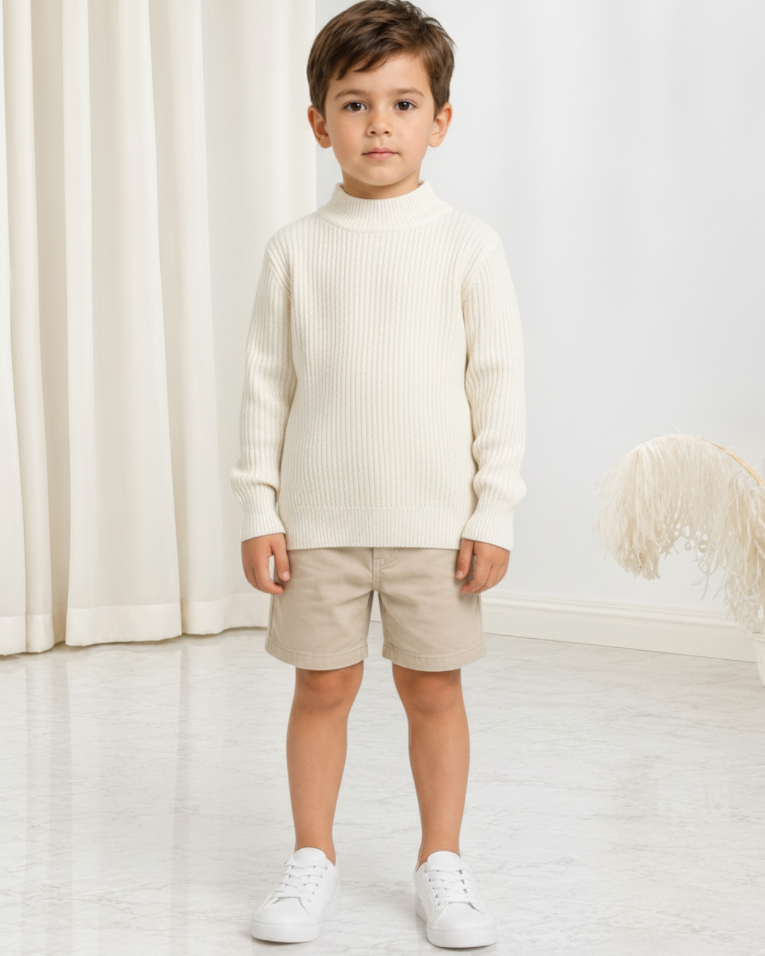 Garçon portant un pull en maille Le Cocon d'Or blanc à col rond, style décontracté pour l'automne et l'hiver.