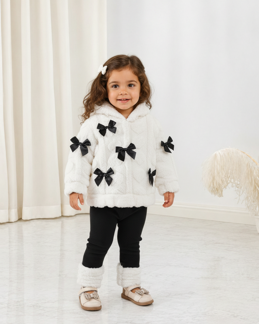 Ensemble Le Cocon d'Or pour bébé avec veste blanche en polaire à nœuds noirs et legging noir assorti