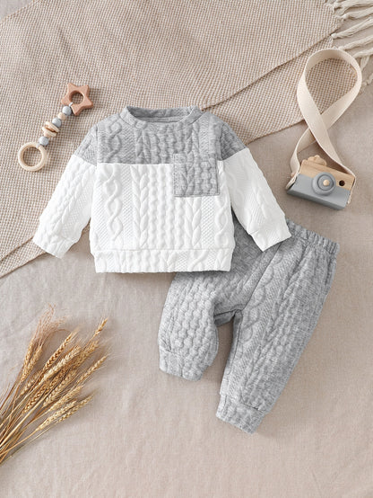 Ensemble d'automne et d'hiver pour bébés garçons, comprenant un haut tricoté à manches longues avec blocs de couleurs gris et blanc, et un pantalon à revers, parfait pour les sorties confortables en extérieur.