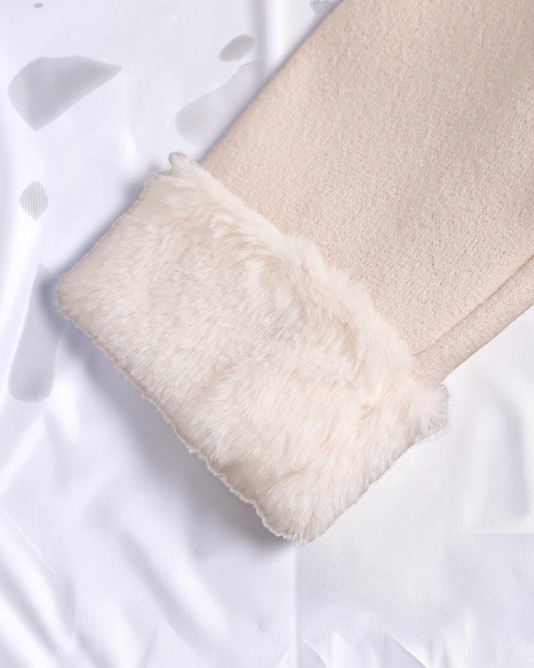 Détail de la manche en fausse fourrure beige de la robe Le Cocon d'Or avec tulle et perles pour petite fille