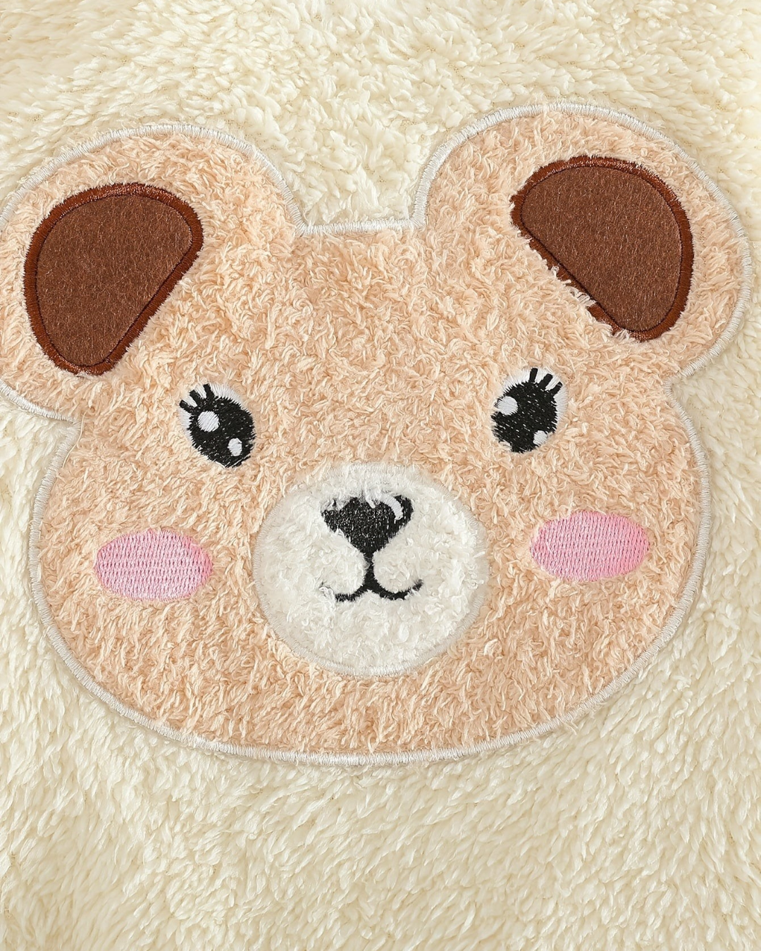Gros plan sur le motif ours en peluche beige et blanc du pyjama Le Cocon d'Or en polyester doux pour bébé