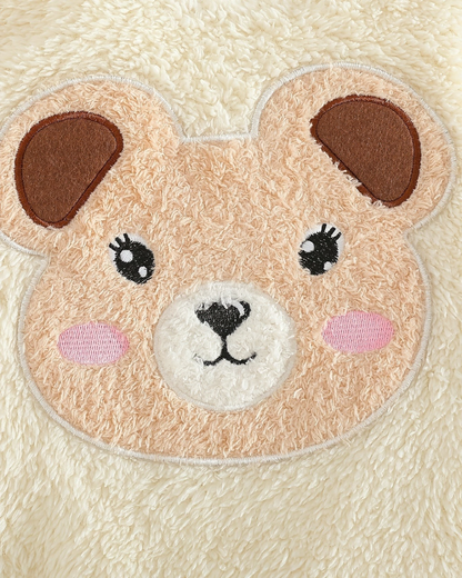 Gros plan sur le motif ours en peluche beige et blanc du pyjama Le Cocon d'Or en polyester doux pour bébé
