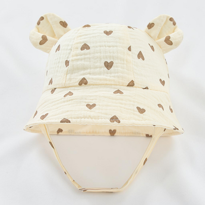 Chapeau bob Le Cocon d'Or pour bébé en coton blanc avec motifs cœurs marron et petites oreilles d'ours décoratives