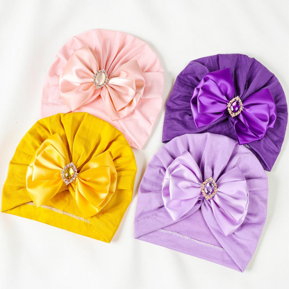 Lot de quatre turbans Le Cocon d'Or pour bébé en maille souple avec nœud décoratif et strass, couleurs variées