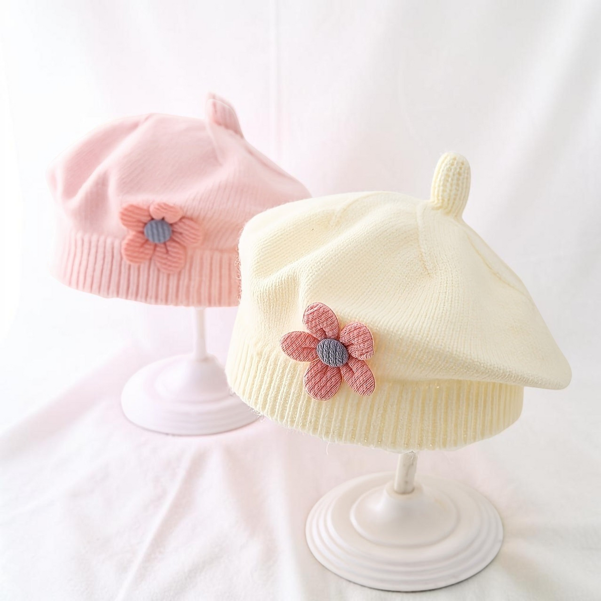 Bonnet beanie Le Cocon d'Or pour bébé en polyester doux avec décoration florale, couleurs pastel rose et jaune.