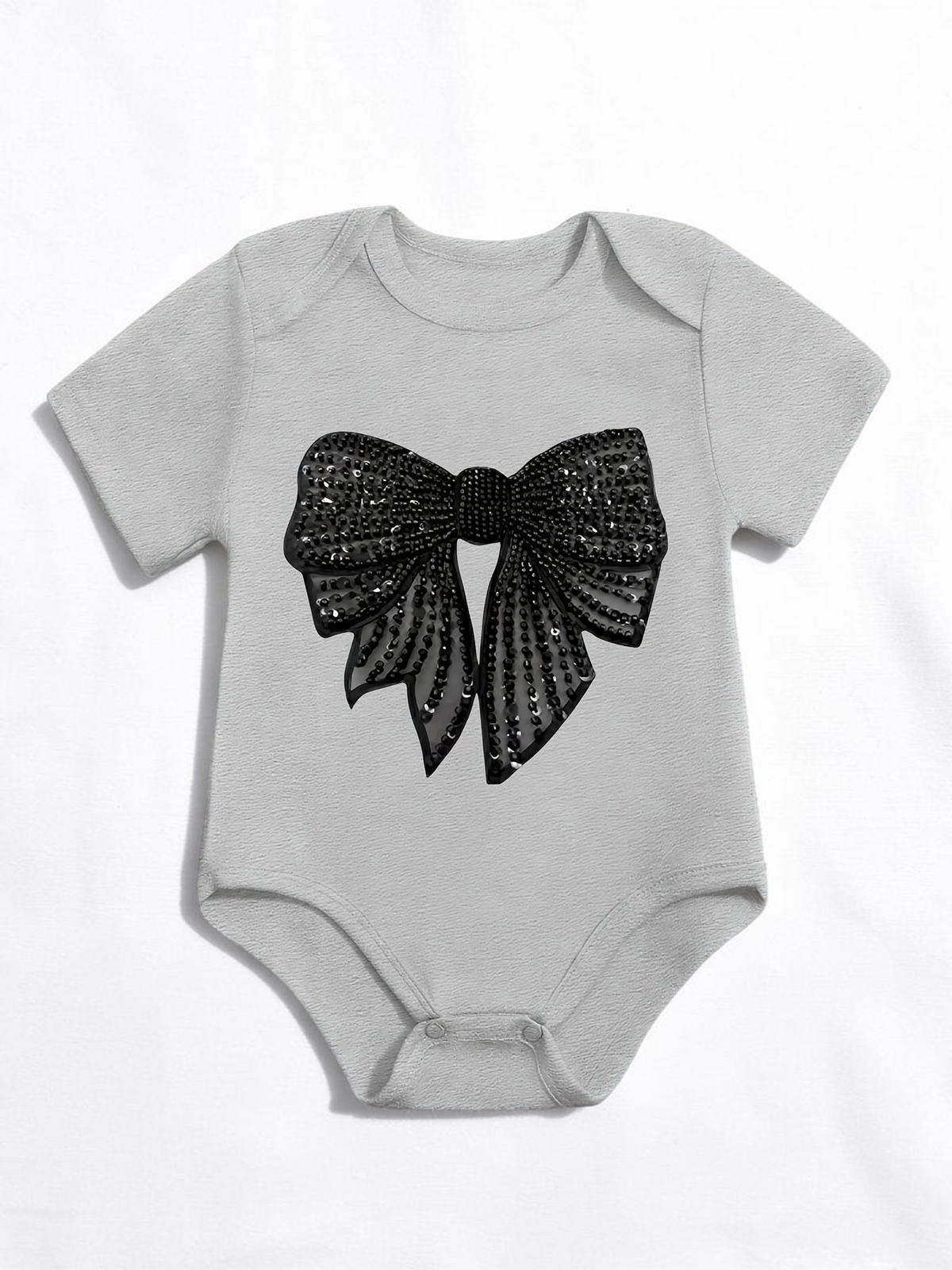 Grenouillère Le Cocon d'Or grise en coton pour bébé fille avec motif nœud noir à paillettes imprimé