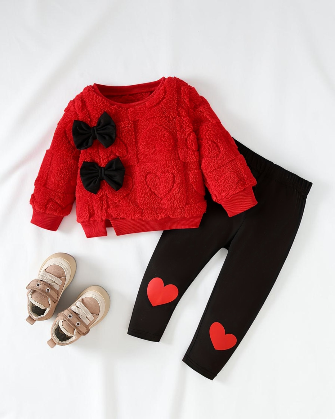Ensemble d'hiver Le Cocon d'Or pour bébé avec pull rouge texturé à nœuds noirs et legging noir à motifs cœurs