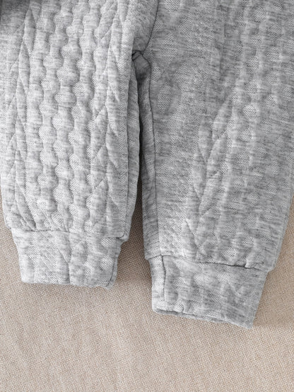 Ensemble d'automne et d'hiver pour bébés garçons, comprenant un haut tricoté à manches longues avec blocs de couleurs gris et blanc, et un pantalon à revers, parfait pour les sorties confortables en extérieur.