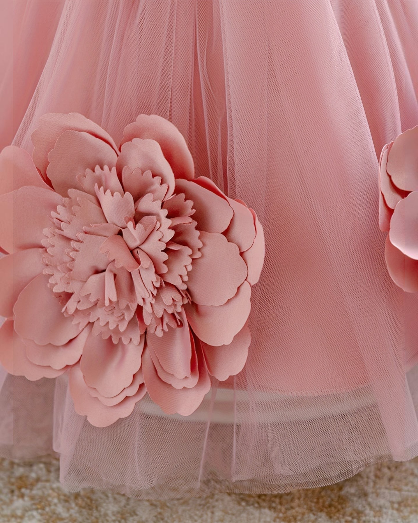 Détail de la robe de princesse Le Cocon d'Or rose avec une grande fleur en tissu 3D sur un tulle délicat