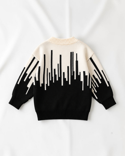 Pull en tricot Le Cocon d'Or pour bébé garçon, noir et blanc avec motif abstrait, col rond et manches longues.