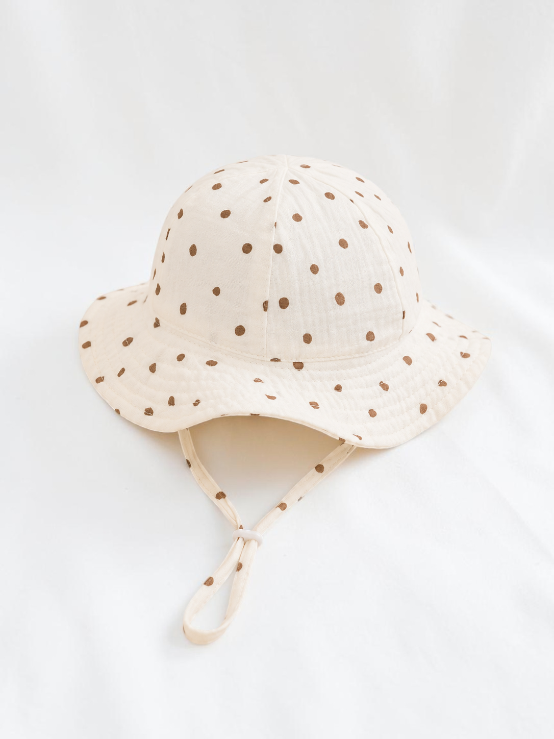 Bob pour bébé Le Cocon d'Or en coton blanc à pois marron avec cordon de serrage pour le printemps et l'été