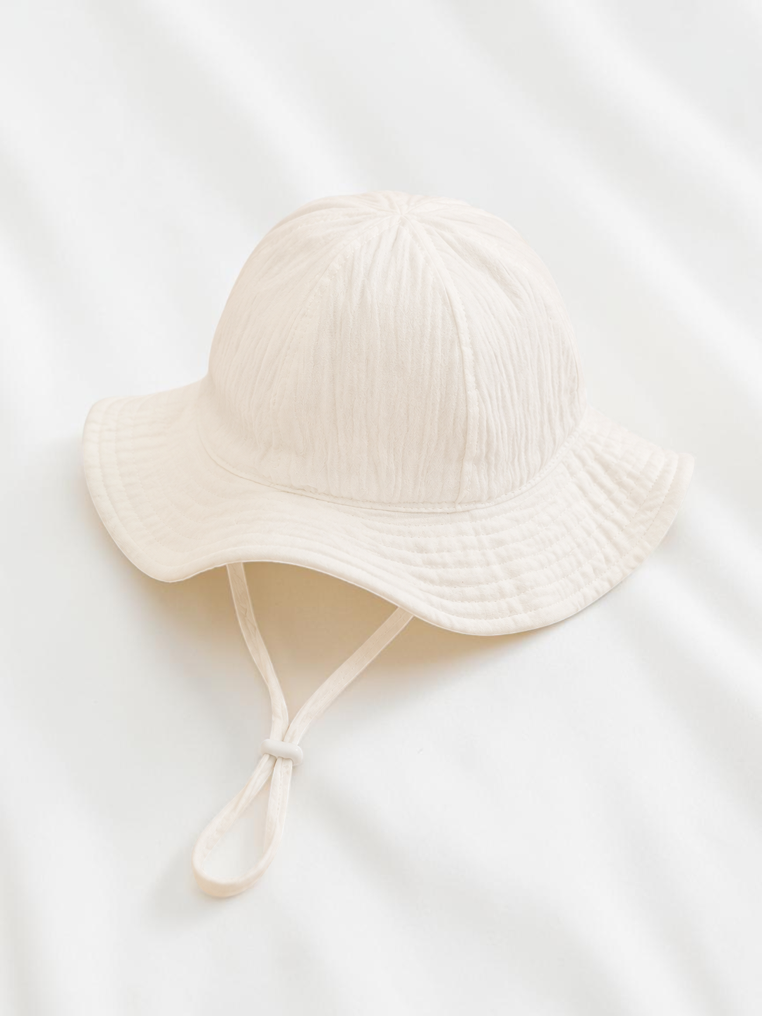 Chapeau bob pour bébé Le Cocon d'Or en coton blanc doux avec cordon de serrage, idéal pour le printemps et l'été.