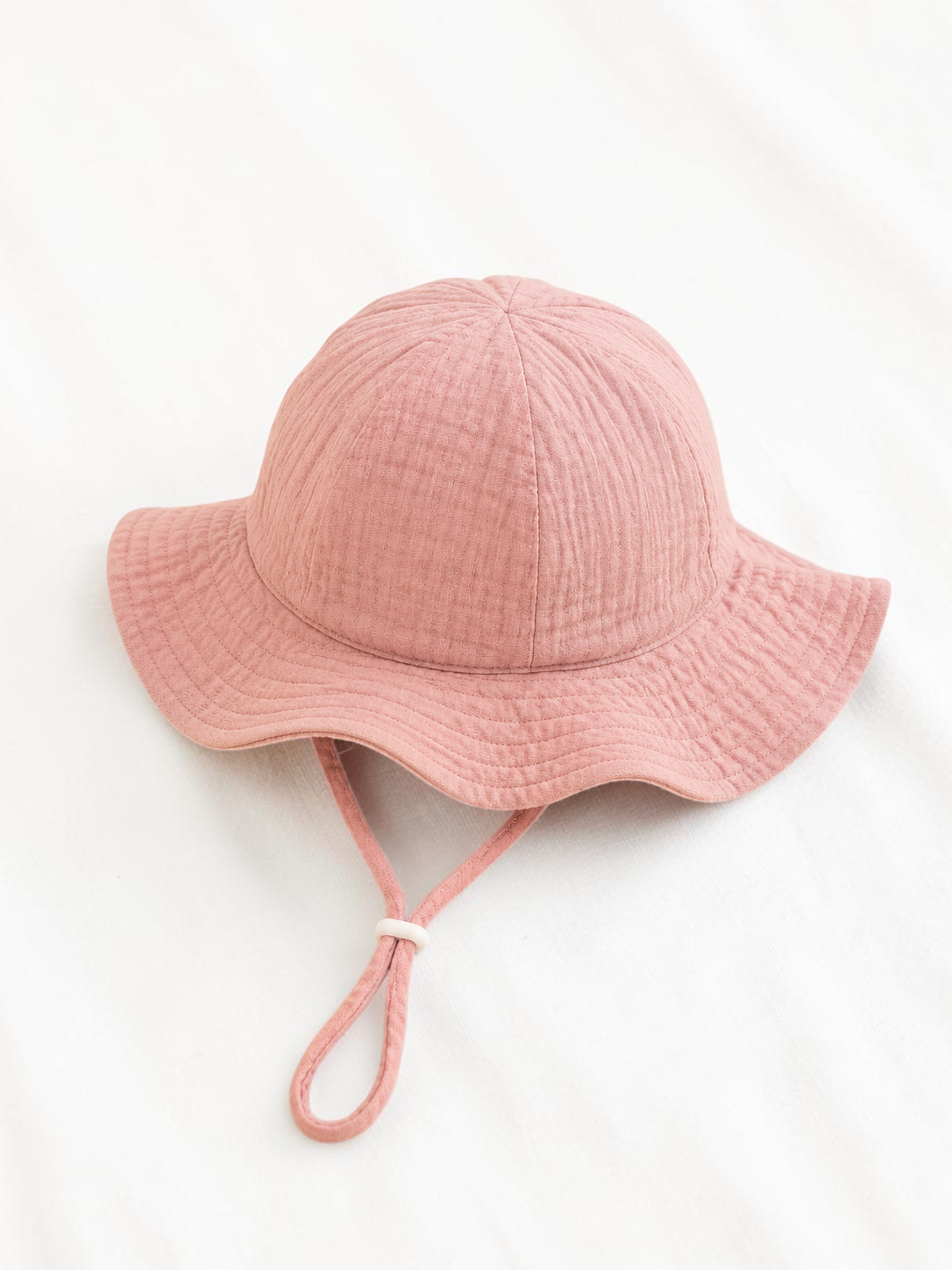 Bob pour bébé Le Cocon d'Or en coton rose avec cordon de serrage, idéal pour le printemps et l'été.