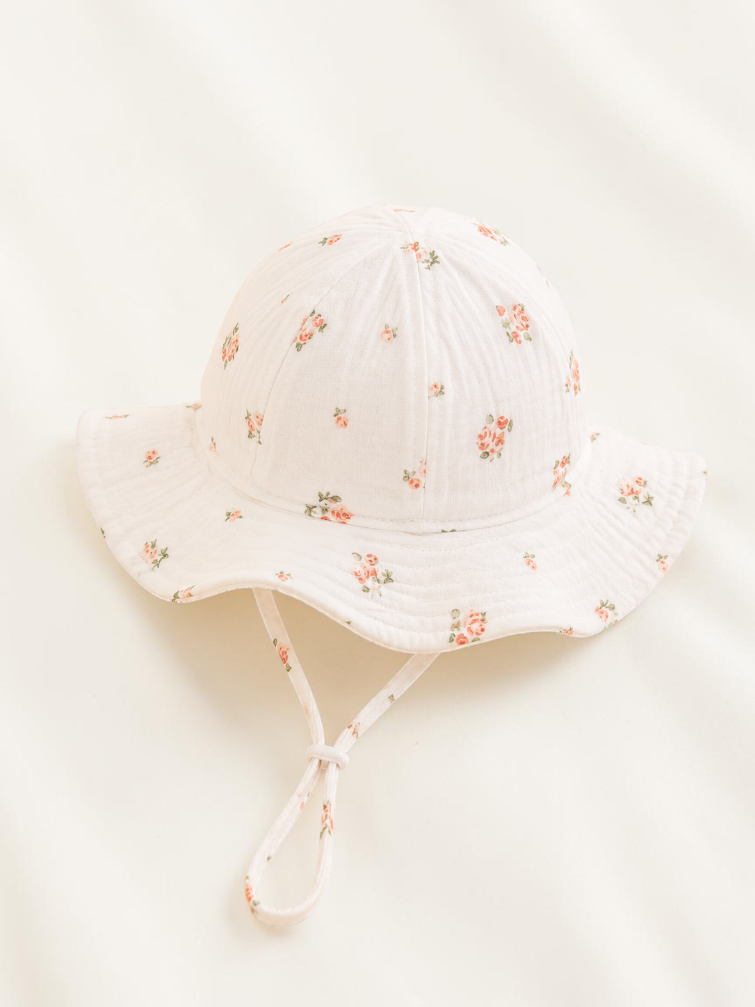 Chapeau bob pour bébé Le Cocon d'Or en coton blanc avec motif de petites fleurs colorées et cordon de serrage