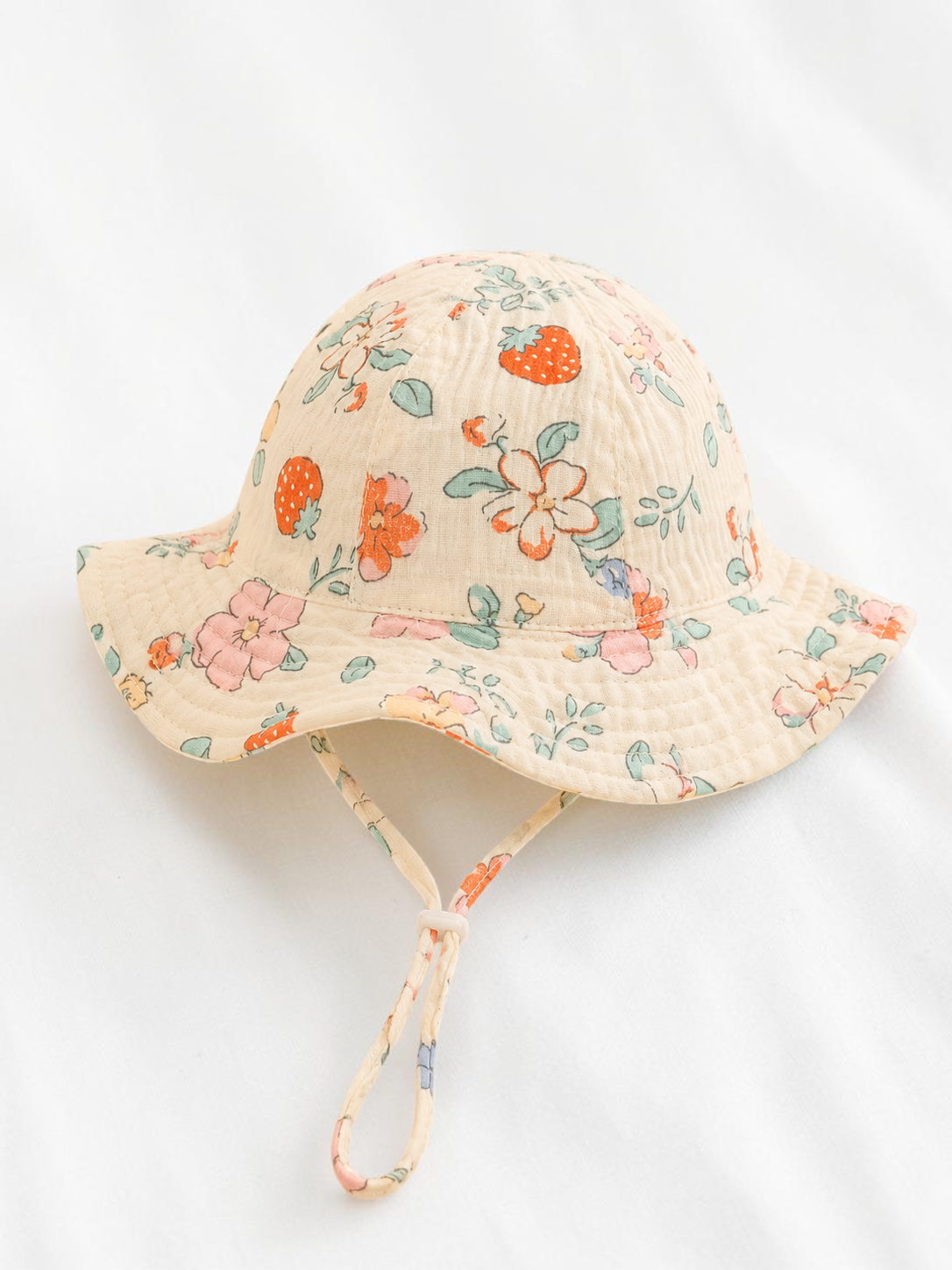 Bob pour bébé Le Cocon d'Or en coton doux avec motif floral et fraises, idéal pour le printemps et l'été.