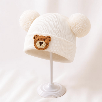 Bonnet bébé blanc Le Cocon d'Or en acrylique avec pompons et motif ours brodé pour l'automne et l'hiver