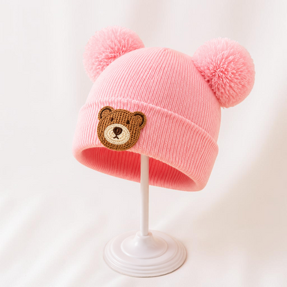 Bonnet rose en maille acrylique Le Cocon d'Or avec pompons et motif ours pour bébé