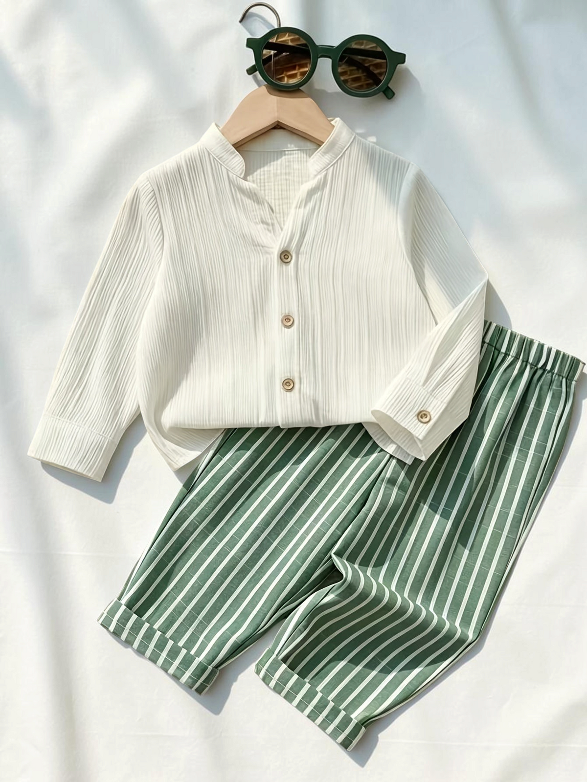 Ensemble Le Cocon d'Or pour garçon avec chemise blanche à boutons et pantalon rayé vert, style décontracté en été.