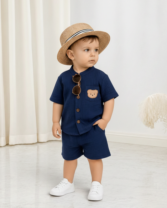 Ensemble Le Cocon d'Or bleu marine en coton pour bébé garçon avec chemise à col montant, short et écusson ourson.