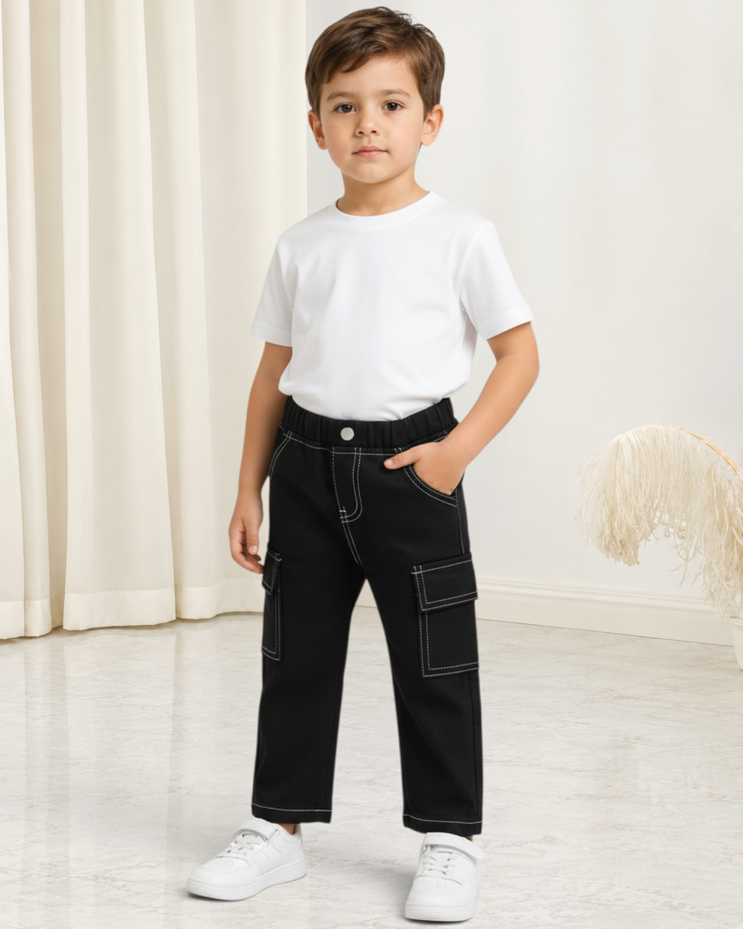Petit garçon portant un pantalon en jean noir Le Cocon d'Or à coupe droite avec poches latérales et surpiqûres