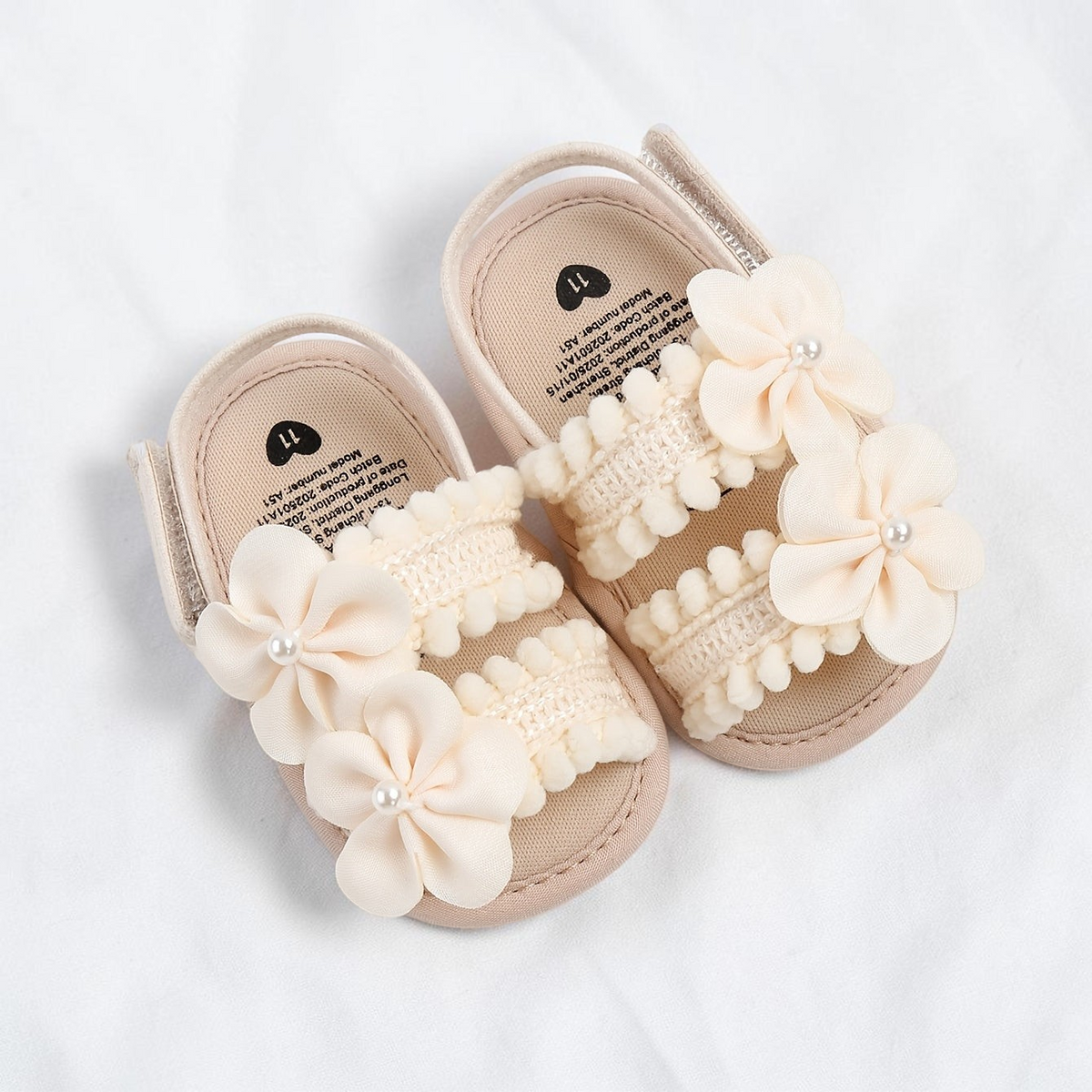 Sandales pour bébé fille Le Cocon d'Or en tissu beige avec fleurs décoratives et fermeture à scratch