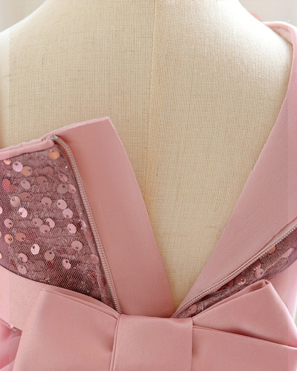 Détail du dos d'une robe de princesse Le Cocon d'Or rose avec sequins brillants, fermeture éclair et nœud élégant