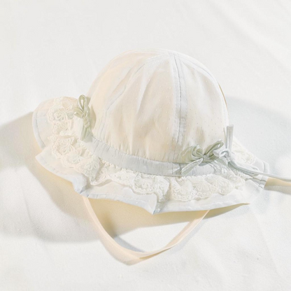 Chapeau de pêcheur blanc Le Cocon d'Or pour bébé en dentelle respirante avec nœuds décoratifs et mentonnière