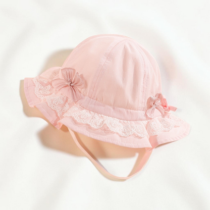 Chapeau de pêcheur Le Cocon d'Or pour bébé en dentelle rose pâle avec nœuds décoratifs et bordure protectrice
