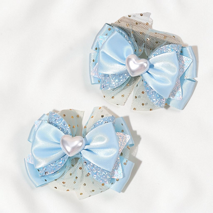 Paire de barrettes Le Cocon d'Or bleu clair en forme de nœud avec tulle pailleté et cœur central nacré