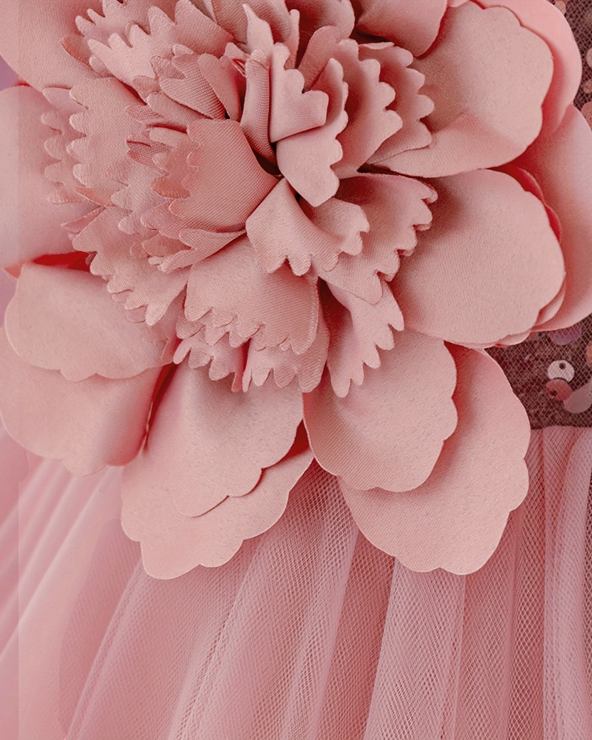 Gros plan sur une fleur en tissu 3D rose sur une robe de cérémonie Le Cocon d'Or pour bébé fille en tulle