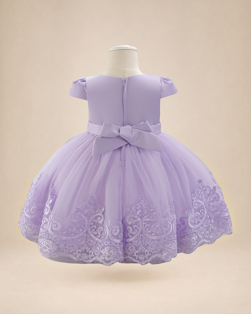 Robe de cérémonie Le Cocon d'Or pour bébé fille, lilas en tulle avec manches à volants et nœud décoratif au dos.