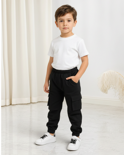 Garçon portant un pantalon cargo noir Le Cocon d'Or en coton avec poches latérales et chevilles élastiques