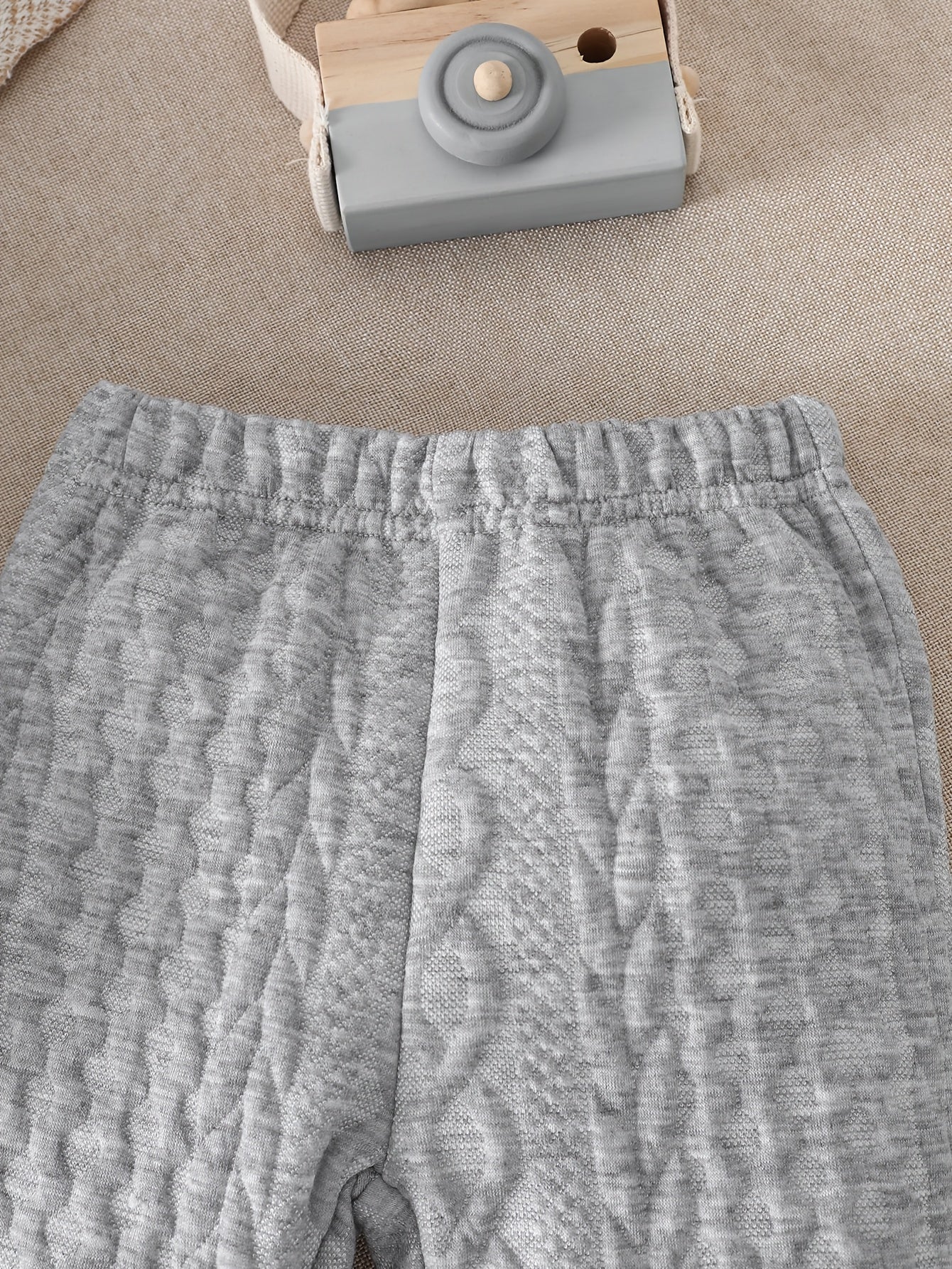 Ensemble d'automne et d'hiver pour bébés garçons, comprenant un haut tricoté à manches longues avec blocs de couleurs gris et blanc, et un pantalon à revers, parfait pour les sorties confortables en extérieur.