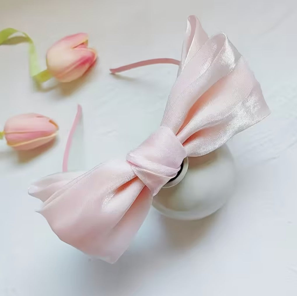 Bandeau Le Cocon d'Or rose pâle en rayonne avec un élégant nœud papillon double épaisseur sur fond blanc